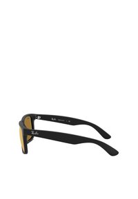 Occhiali da sole neri con design angolare, finitura opaca e lenti color oro. Presentano il marchio Ray-Ban sulla tempia e sulla cerniera.