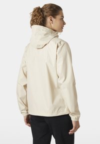 Lichtbeige gewatteerde jas met een capuchon, elastische manchetten en een rugpas. Gladde, waterafstotende stof, met een minimalistisch ontwerp en zonder zichtbare hardware.