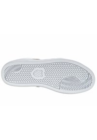 White sneaker sole with a textured rubber surface, featuring a herringbone pattern and a logo detail in the center.