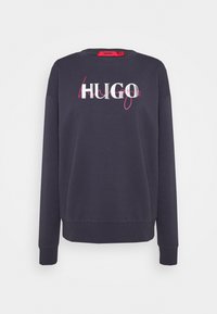 Námořnický svetr s žebrovanými rukávy a lemem, na přední straně s výrazným logem "HUGO" v bílé a růžové barvě.