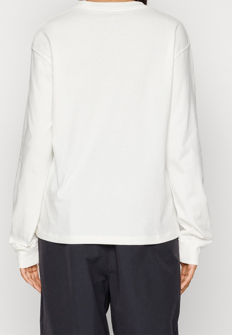 Langärmliges, Rundhals-T-Shirt aus off-white Baumwolle mit lockerer Passform, gerippten Bündchen und glatter Textur. Schlichte Rückseite, ohne Muster oder Akzente.