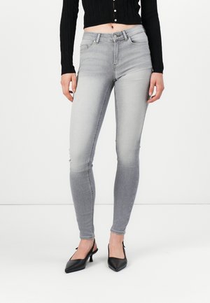 Les jeans skinny gris présentent une texture en denim lisse avec un lavage délavé, une taille haute et un design standard à cinq poches.