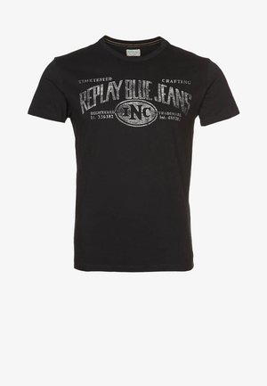 T-shirt noir à manches courtes avec texte blanc usé "Replay Blue Jeans Inc" et petits détails imprimés supplémentaires sur la poitrine.