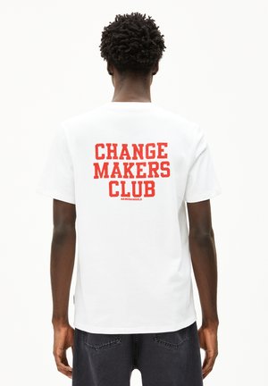 Witte katoenen t-shirt met op de achterkant in dikke rode tekst "CHANGE MAKERS CLUB." Klassiek ontwerp met ronde hals en korte mouwen.