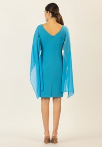 Teal Kleid mit V-ausschnitt, taillierter Passform, transparenten Kapuzenärmeln und knielangem Saum. Der Stoff hat eine glatte Textur und verfügt über einen zentralen Reißverschluss hinten.