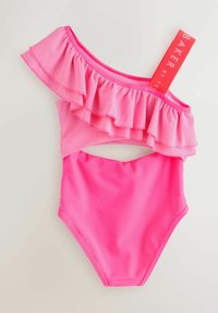 Eén-schouder roze badpak met ruches. Glad materiaal, uitsparing aan de zijkanten en een gedurfde, contrasterende merklabel eraan bevestigd.