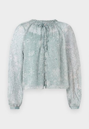 Blouse légère bleu clair en tissu transparent avec un motif floral, encolure froncée, manches bouffantes longues et fermeture à boutons sur le devant.