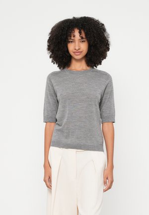 Grijs gebreide trui met korte mouwen en een ronde halslijn, met een gladde textuur en subtiele tonale variaties, gecombineerd met lichtgekleurde op maat gemaakte pantalons.