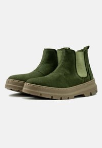 Botas de ante de color verde oscuro hasta el tobillo con paneles elásticos laterales y suelas de goma texturizada, que presentan un diseño clásico de bota Chelsea.