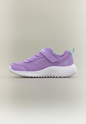 Zapatilla individual lavanda con parte superior de malla, cierre de velcro, detalles en azul claro y gruesa suela blanca texturizada, mostrada sobre fondo neutro.
