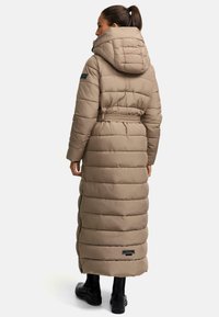 Lange beige donsjas met een getailleerde taille, capuchon, geborduurde textuur en ritszakken. Geaccentueerd met een merklabel op de achterkant.