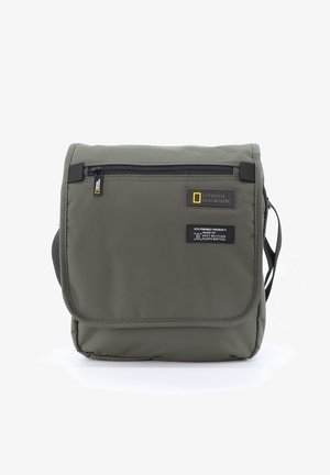 Grüne Nylon-Schultertasche mit Klappe, ausgestattet mit einer Reißverschlusstasche, Logo und umweltfreundlichem Etikett. Kompaktes, rechteckiges Design mit einem Schultergurt.