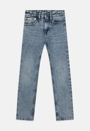 Suorat, vaaleansiniset farkut, joissa on etutaskut, vyölenkit ja napillinen suljenta, aseteltuna tasaisesti valkoiselle taustalle.