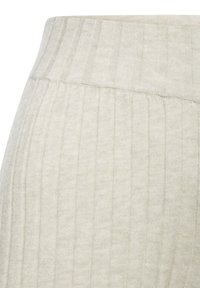 Lichtgrijze geribde leggings met een zachte, gestructureerde stof, een brede tailleband en verticale strepen die langs het materiaal lopen.