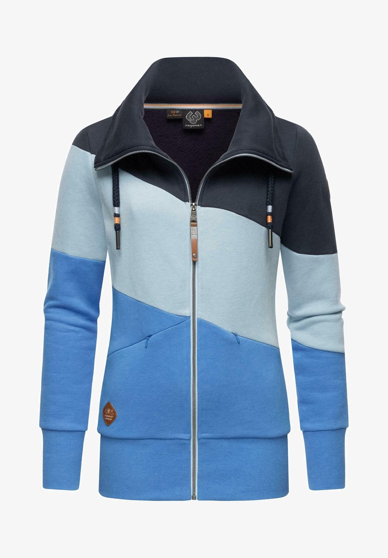 Veste femme zippée avec col montant, color-block bleu marine, bleu clair et bleu moyen, avec poches avant et détail cordon.