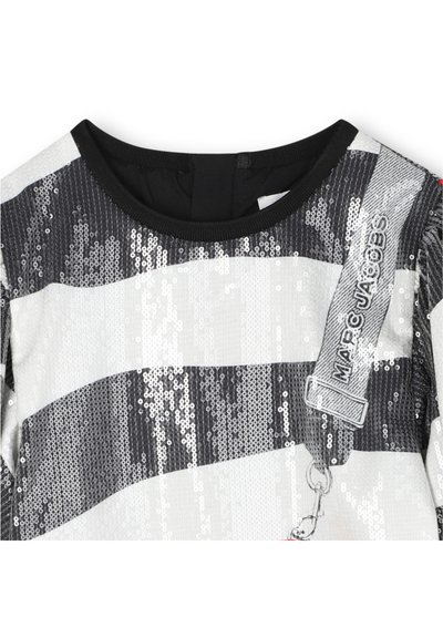 Csillogó felső fekete-fehér csíkos mintával, kerek nyakkivágással és fekete szegéllyel. "Marc Jacobs" címkével és kampós rögzítéssel.
