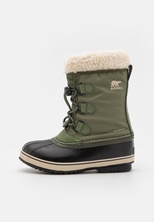 Bota de invierno impermeable verde y negra con forro de lana beige, cierre con cordones en el frente y suela resistente para uso en exteriores con nieve.