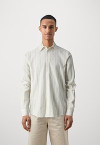 Striped button-up shirt in light beige with thin vertical lines in cream and taupe. Features a classic collar and long sleeves.
