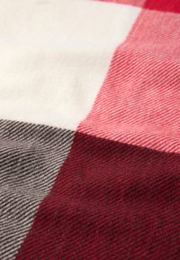 Tissu à carreaux rouge, blanc et gris avec une finition douce et texturée. Le motif présente de grands carreaux de différentes nuances.