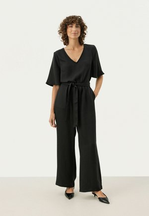 Black jumpsuit with a V-neck, short sleeves, and a waist tie. Made of smooth fabric with wide legs and minimal design details.