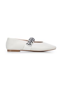 Zapatos planos blancos con punta afilada, que presentan un acento de cadena plateada brillante y una textura de cuero suave. Suela marrón, diseño minimalista.