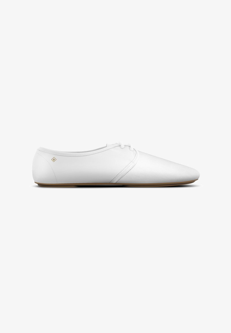Weiße elegante Leder-Schnürschuhe mit flacher Sohle und tanfarbener Sohle sowie minimaler dekorativer Naht, seitlich dargestellt.