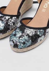 Wedges de espadrilles de lentejuelas negras y plateadas con una plataforma de cuerda de yute, que presentan una punta redonda y una plantilla de cuero suave.