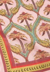Gepatterneerde stof met ingewikkelde bloemmotieven in warme kleuren op een lichtroze achtergrond, omzoomd met decoratieve lijnen in rood en groen.