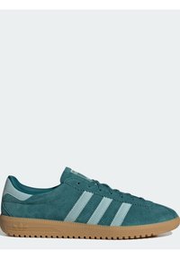 Teal suede sneaker with light teal accents, three stripes, and a gum rubber sole. Features laces and a low-profile design.
