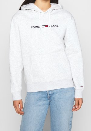 Hoodie gris clair en tissu doux, avec une poche avant, un capuchon à cordon de serrage et le logo "TOMMY JEANS" brodé sur la poitrine.