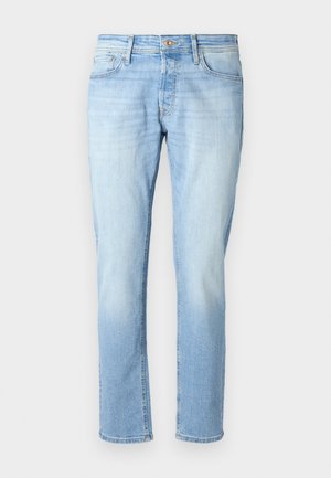 Lichtblauwe denim jeans met een recht model, vijf zakken en een koperen knoop in de taille. Vervaagde structuur richting de onderkant.