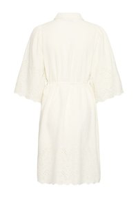 Robe blanche jusqu'aux genoux avec des manches et un ourlet en dentelle ajourée large, taille ceinturée et col, vue de dos.