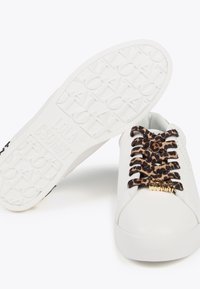 Bijele tenisice s vezicama u uzorku leoparda i zlatnim detaljima. Gornjište od glatke kože, teksturirana gumena potplata s logotipom.