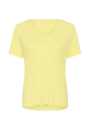Vaaleankeltainen, lyhythihainen V-kaula-aukollinen naisten T-paita, jossa on hieman kaartuva helma ja "Cream"-merkkilappu kaula-aukon sisäpuolella.