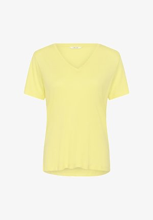 Vaaleankeltainen, lyhythihainen V-kaula-aukollinen naisten T-paita, jossa on hieman kaartuva helma ja "Cream"-merkkilappu kaula-aukon sisäpuolella.