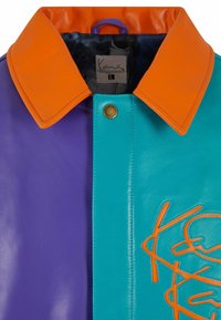 Kožená bunda s velkým oranžovým límcem, představující purpurovou stranu a tyrkysový předek, zdobená oranžovým prošíváním a logem.