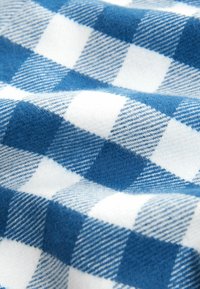 Tela a cuadros azul y blanco con una textura suave y peluda, que presenta un clásico patrón de cuadros en colores alternos y un acabado fino.