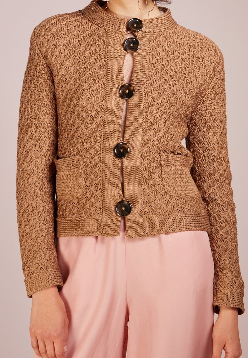 Cardigan lavorato a maglia marrone con un motivo testurizzato, dotato di un colletto alto e sei grandi bottoni neri, oltre a due tasche frontali.