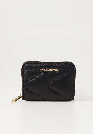 Portefeuille en cuir noir avec un design matelassé, doté d'une fermeture éclair dorée et d'un logo sur le devant. Forme compacte et rectangulaire.