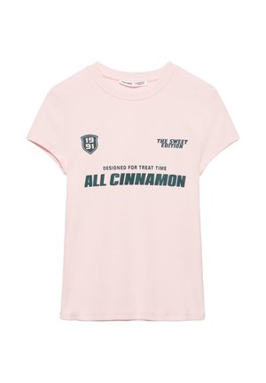 T-shirt à manches courtes rose clair avec texte vert foncé "ALL CINNAMON," "THE SWEET EDITION," "DESIGNED FOR TREAT TIME," et un logo écusson "1991".