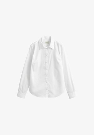 Chemise blanche à manches longues avec col pointu, poignets boutonnés et ourlet droit, présentée sur un fond uni.
