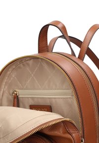 Zaino in pelle marrone con cerniere dorate, dotato di fodera interna beige, tasca interna con cerniera e doppie cinghie regolabili.