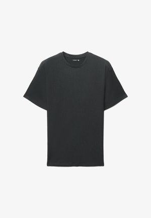 T-shirt nera a maniche corte in tessuto strutturato, con scollo rotondo e vestibilità comoda. Nessun logo o dettaglio visibile.