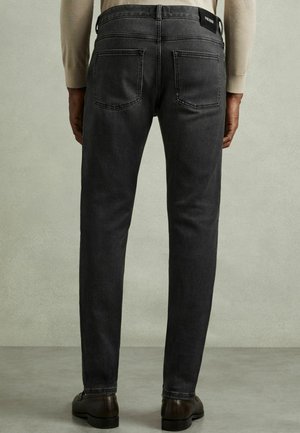 Donkergrijze denimjeans met een slim fit, voorzien van een hoge tailleband, twee achterzakken en subtiele stikdetails.