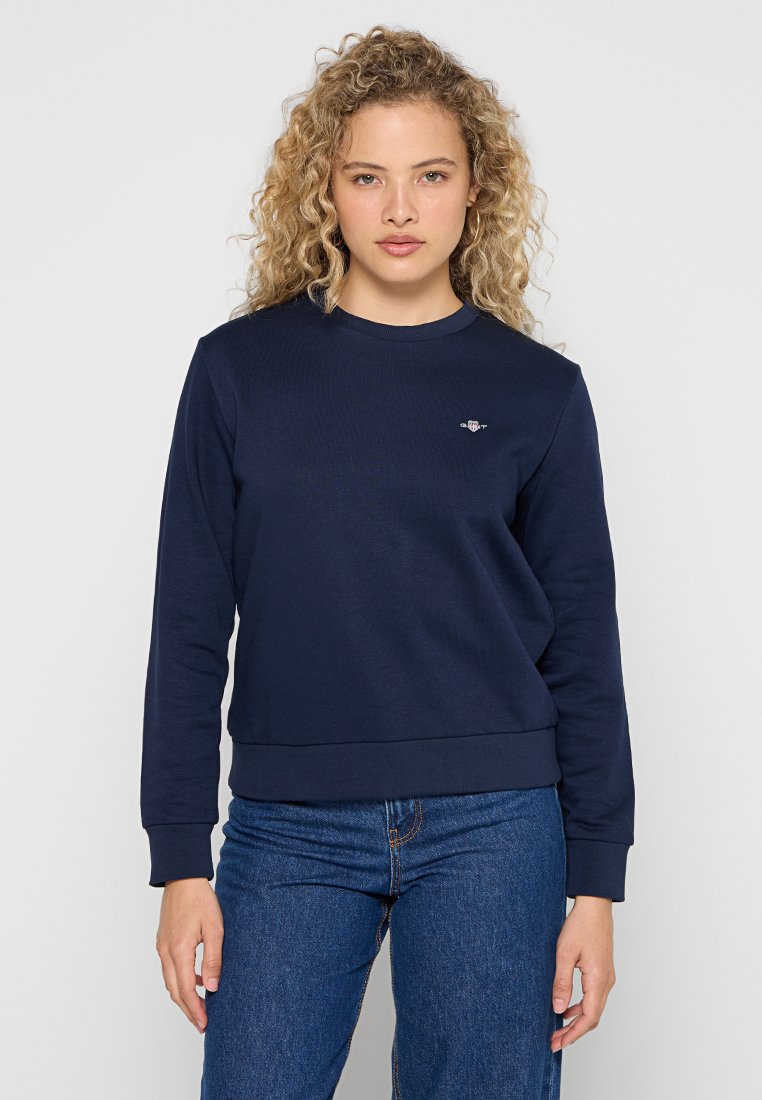 Dunkelblauer Sweatshirt mit Rundhalsausschnitt, gerippten Bündchen und Saum. Verfügt über ein kleines Logo auf der Brust. Hergestellt aus weichem, strukturiertem Stoff.