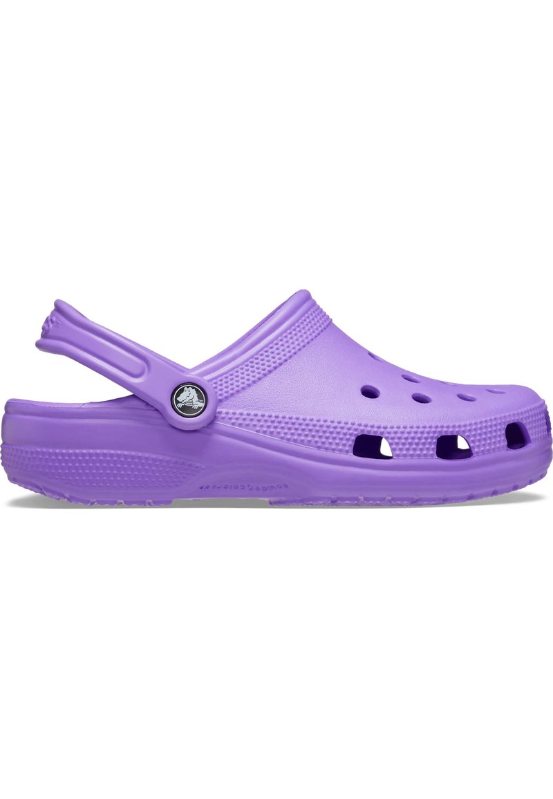 Zoccoli Crocs viola con punta arrotondata, fori di ventilazione, cinturino sul tallone, lati testurizzati e un pulsante logo sul cinturino. Realizzati in materiale impermeabile.