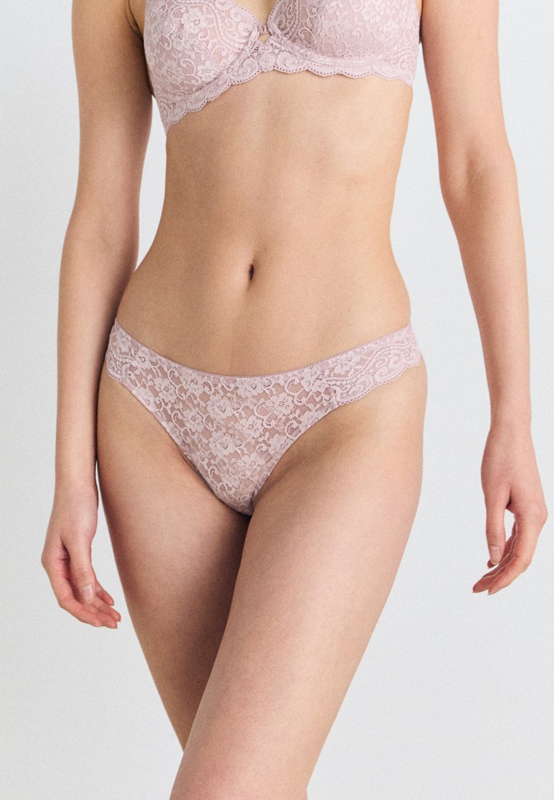 Lichtroze kanten lingerieset met een bloemenpatroon, geschulpte randen en een gladde tailleband. Ontworpen voor een vrouwelijke silhouet.