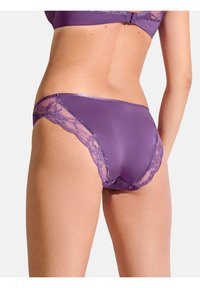 Paarse onderbroek met kantdetails langs de randen, gemaakt van een gladde satijnachtige stof. Het ontwerp is hoog uitgesneden op de heupen.