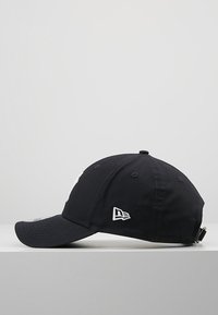 Black baseball cap with a curved brim, embroidered white logo on the front, and an adjustable strap at the back. Cotton material.