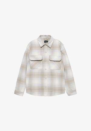 Kariertes Hemd in Beige, Hellblau und Weiß; mit Knopföffnung vorne, spitzen Kragen und zwei Brusttaschen. Weiche Stoffstruktur.